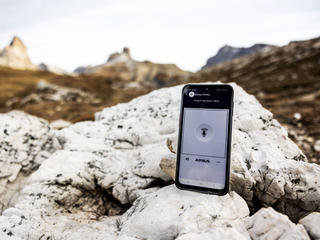 Agnet on a smartphone with a mountain view on the background