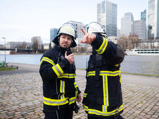 Firemen communicating with a Tetra terminal and Agnet on a smartdevice