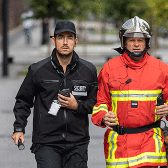 security and fireman running in the street phone in their hand