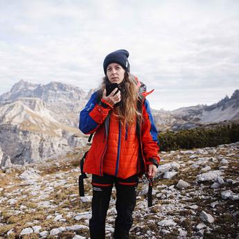 Hiker woman using Agnet over satcom with her smartphone in the mountains