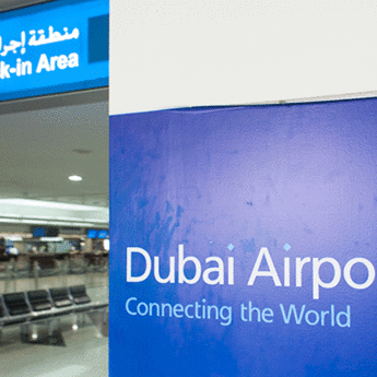 dubai airports sign "connecting the world" next to check in area