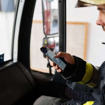 Fireman using Agnet PTT feature on his smartphone in his fire truck