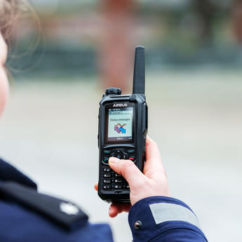 Police officer scrolling the menu of a TH9 TETRA terminal