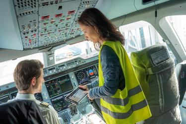 aircraft turnaround maintenance woman showing agnet turnaround on tablet to the pilot in the cockpit