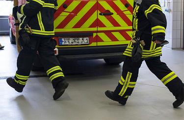close bottom view on two firefighters running into a fire truck in the fire station close bottom view on two firefighters running into a fire truck in the fire station