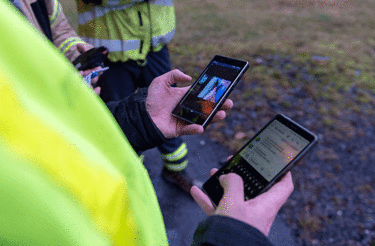 Close view on Fireman holding two smartphones in his hands showing Agnet Close view on Fireman holding two smartphones in his hands showing Agnet