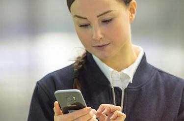 Female security officer uses a smartphone