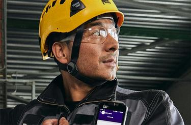 Industry worker uses external PTT with smartphone and Agnet Industry worker uses external PTT with smartphone and Agnet