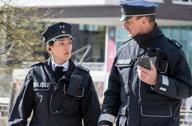 Two German police officers walking and Tactilon Dabat in hand Two German police officers walking and Tactilon Dabat in hand