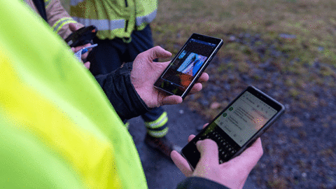 agnet push to talk - industry user using the app with 2 phones in hand