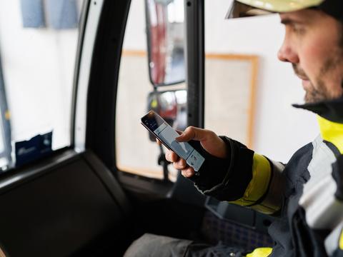 Fireman using Agnet PTT feature on his smartphone in his fire truck