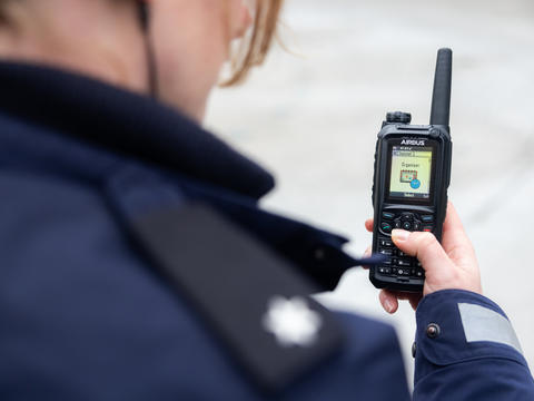 public_safety_worker_holding_a_tetra_device.jpg