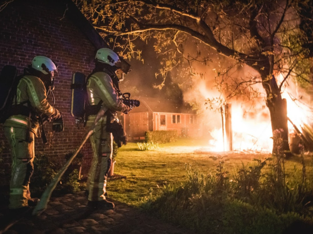 Firemen - 2 firemen fighting a forest fire at night