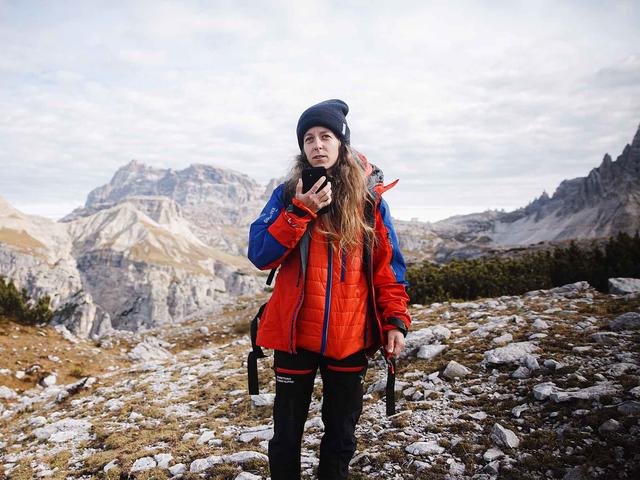 Hiker woman using Agnet over satcom with her smartphone in the mountains