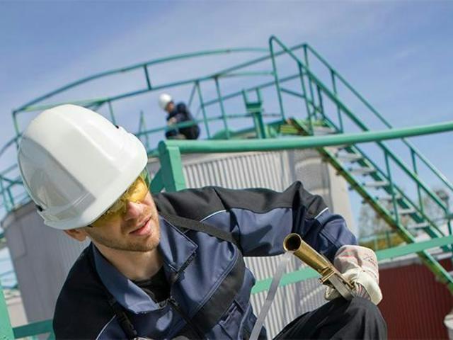 Industrial user in front of oil containers