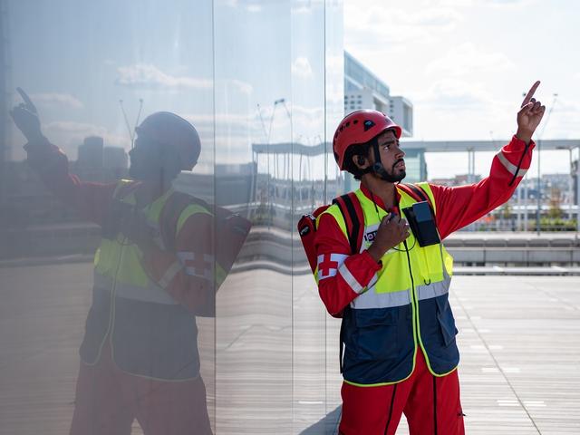 Paramedic man using PTT device and pointing his finger on top