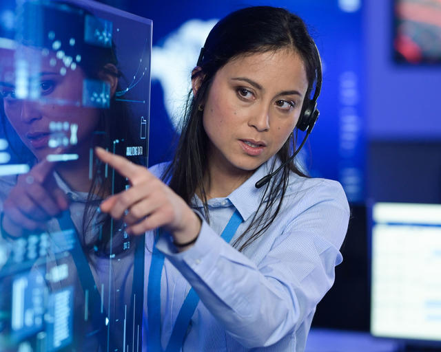 Command and control room operator pointing out an interesting fact from a transparent screen