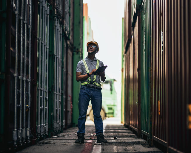Dock worker checking the cargo and informing about it with Agnet on a tablet