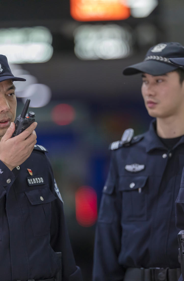 TETRA - Guangzhou police speaking to a device with other two standing next to him