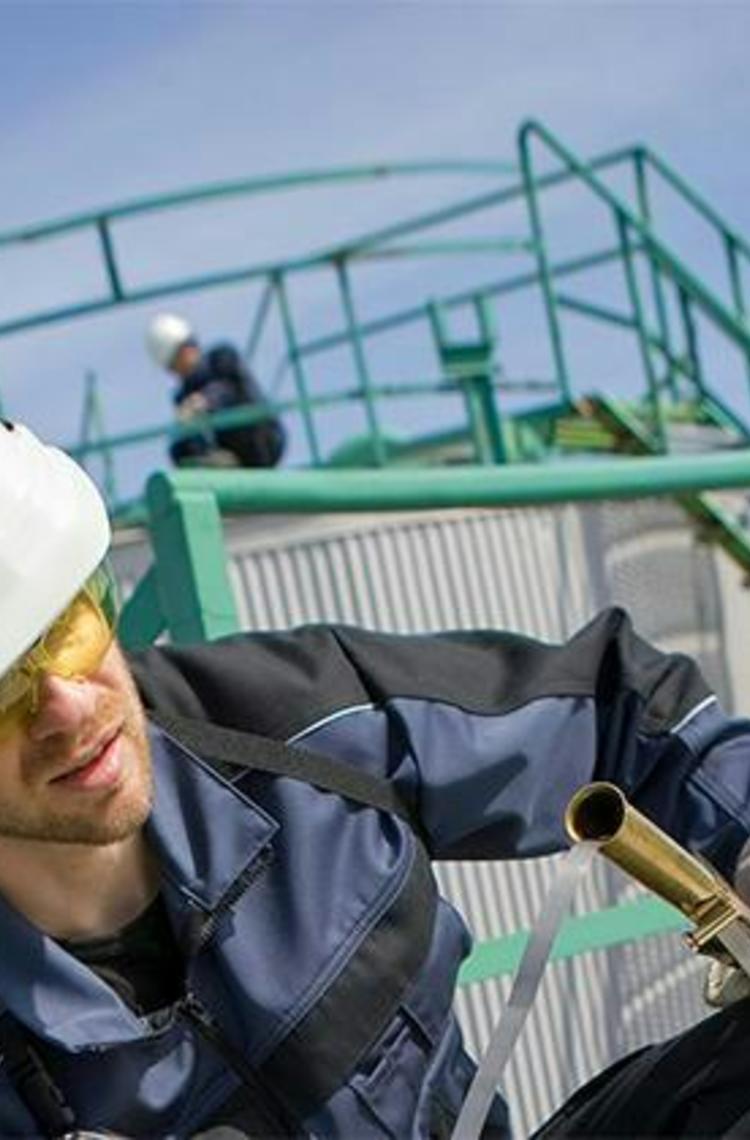 Industrial user in front of oil containers