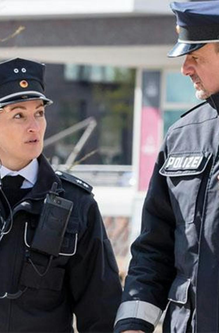 Two German police officers walking and Tactilon Dabat in hand