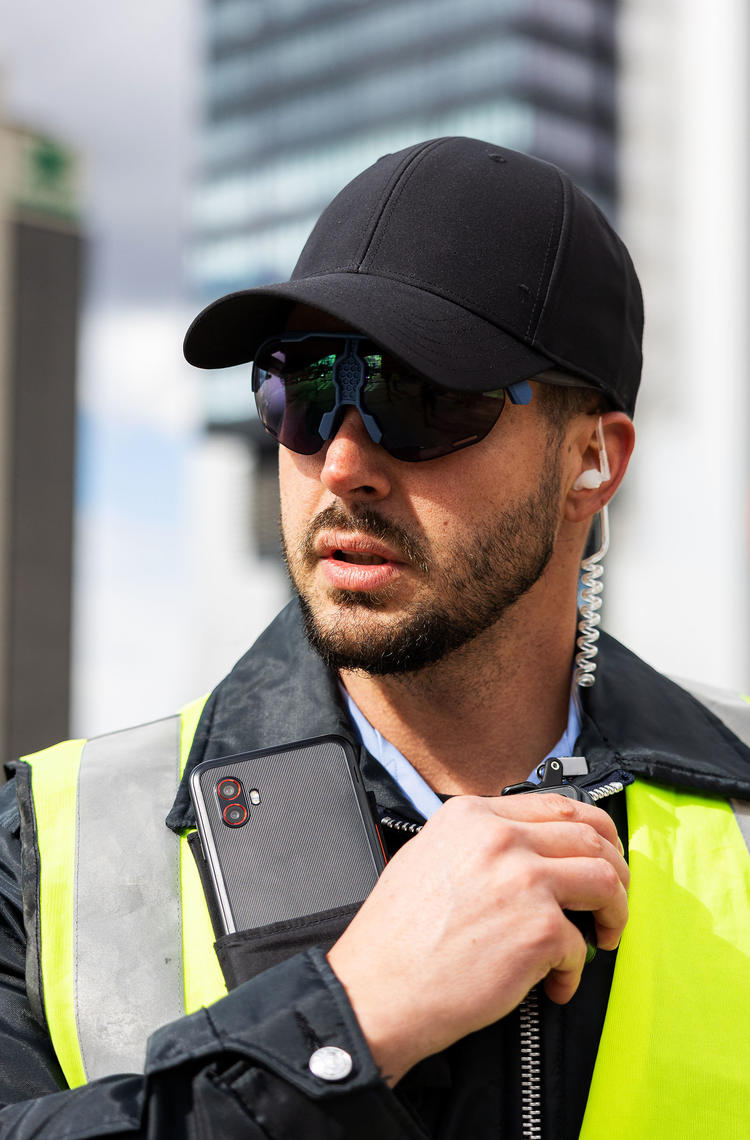 Police officer wearing a smarthphone, smartglasses and a ptt device