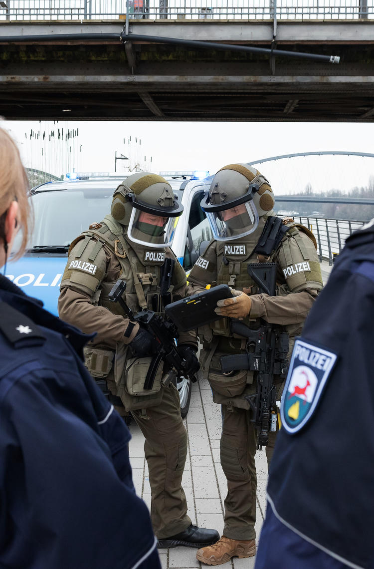 Swat officers using Agnet tacteam on a tablet with police officers on the foreground Swat officers using Agnet tacteam on a tablet with police officers on the foreground