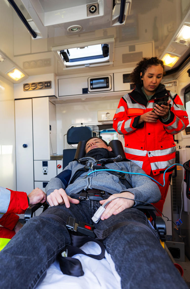 Paramedics treating a patient in the back of an ambulance Paramedics treating a patient in the back of an ambulance