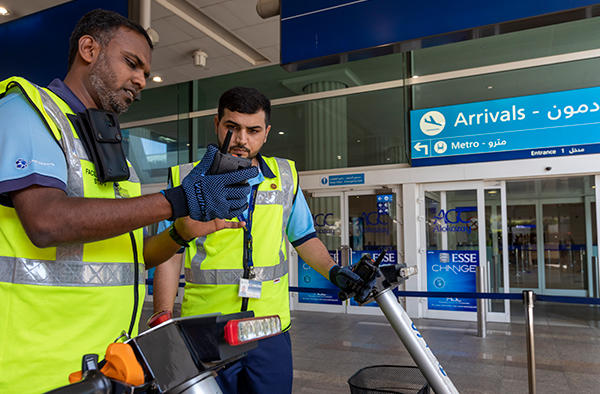 dubai airport trolley staff with tactilon dabat device outside the arrivals