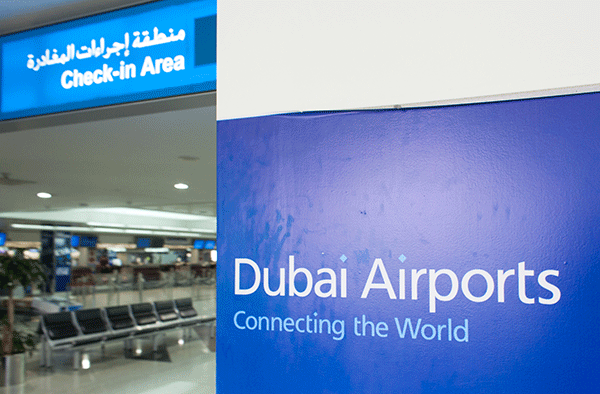 dubai airports sign "connecting the world" next to check in area